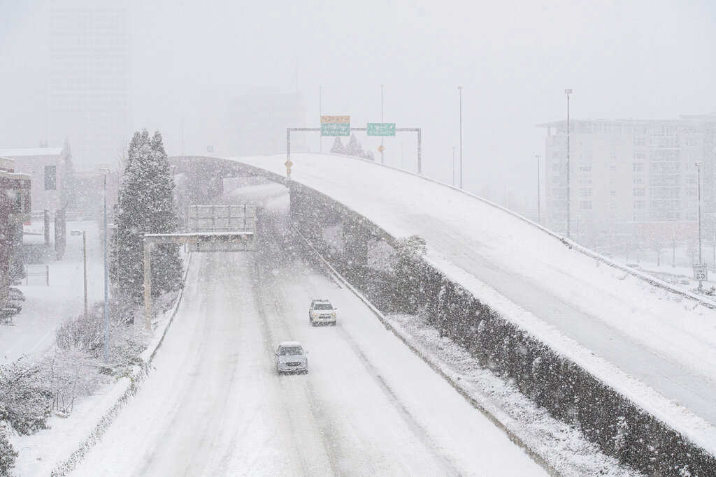 暴风雪、缺水、断电：美国遭遇创纪录冬季严寒。华盛顿州塔科马市705号州际公路上的汽车在雪中行驶